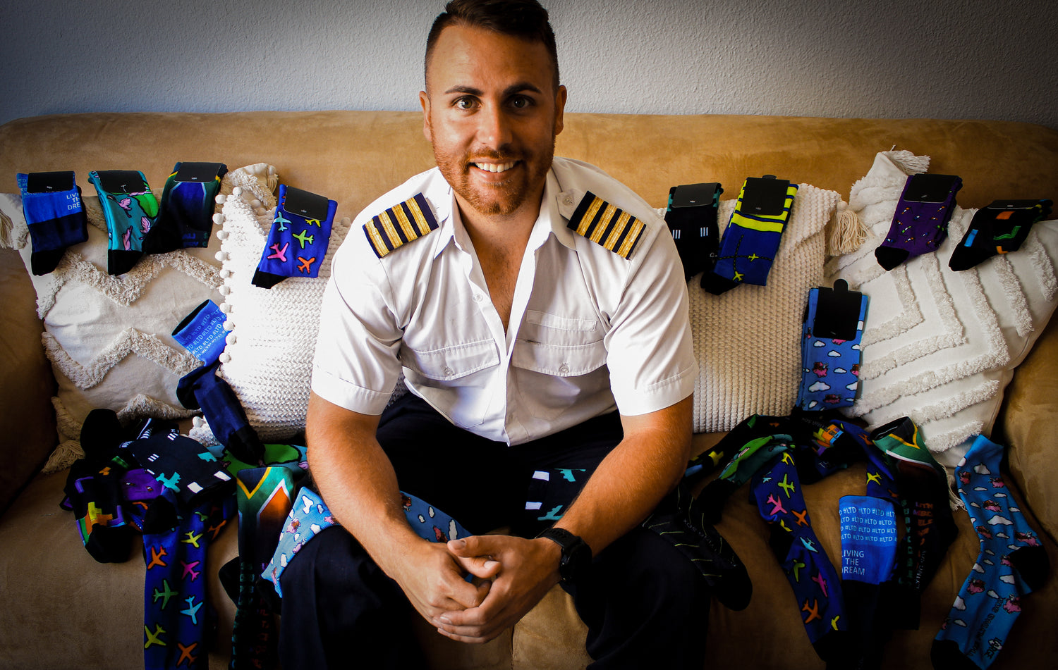 A pilot with pairs of Flying socks sitting on a couch
