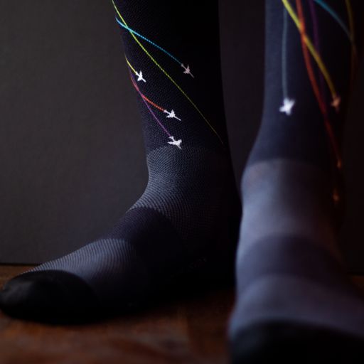 Colourful trail socks on a foot model with a black background