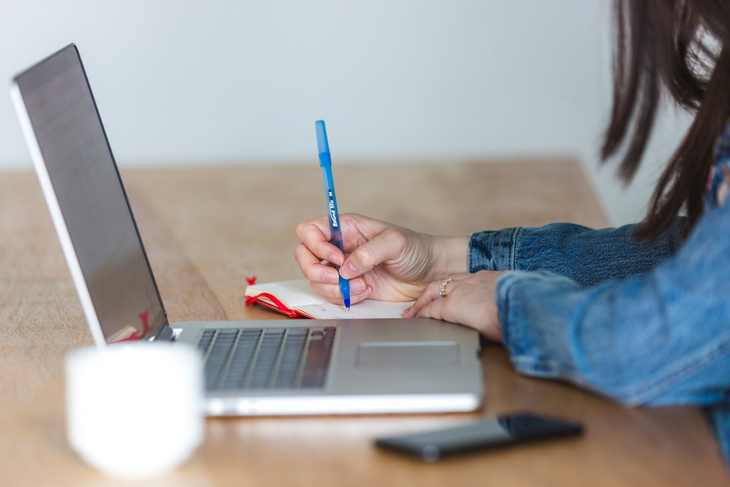 Taking notes and a laptop on the table with coffee and mobile phone.
